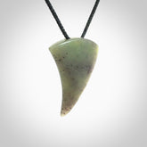 This is a lovely New Zealand Jade, pounamu niho drop pendant. It is bound with an adjustable black coloured cord which is length adjustable.